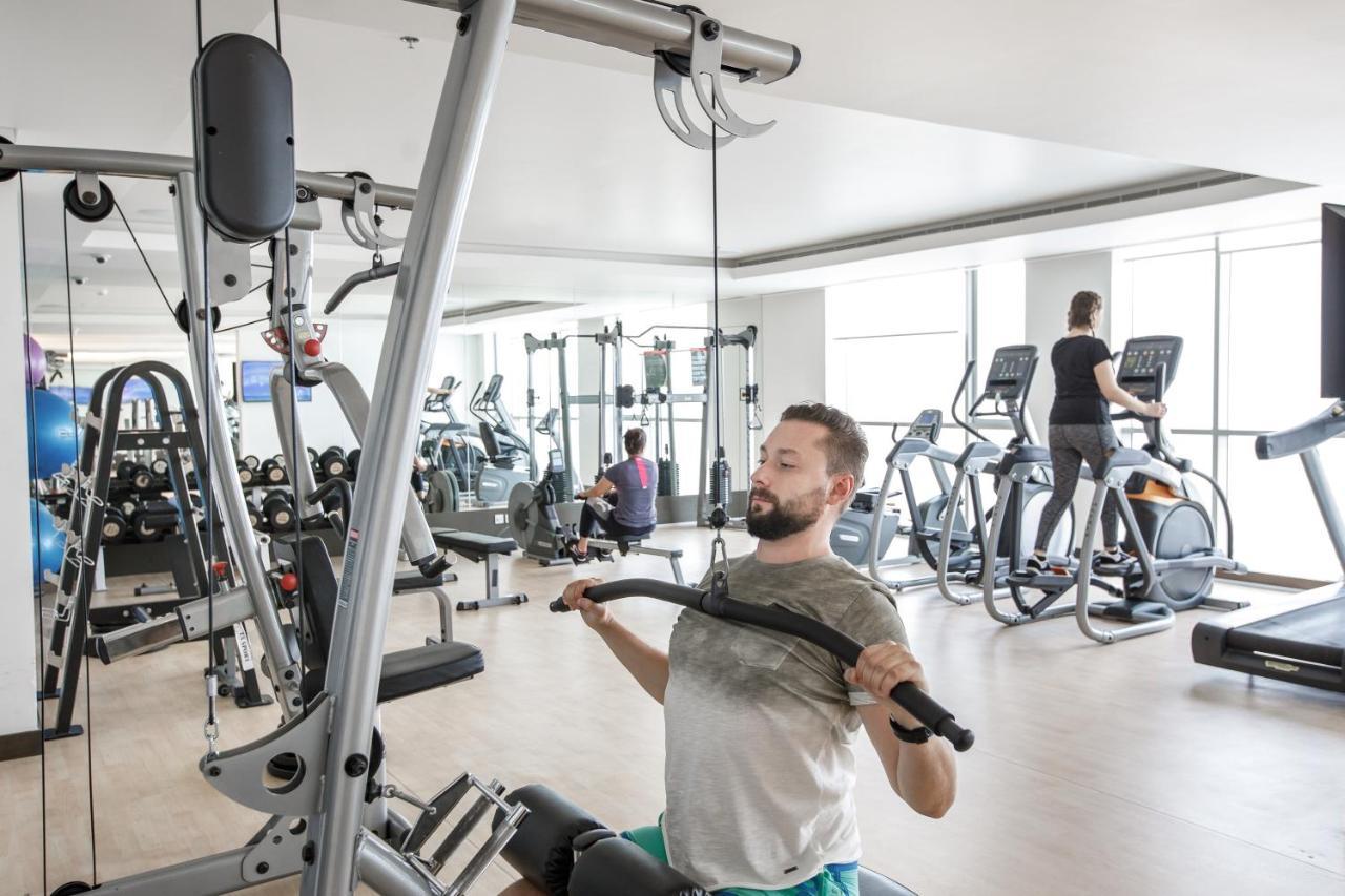 Royal M Hotel Fujairah By Gewan Zewnętrze zdjęcie A man using a lat pulldown machine